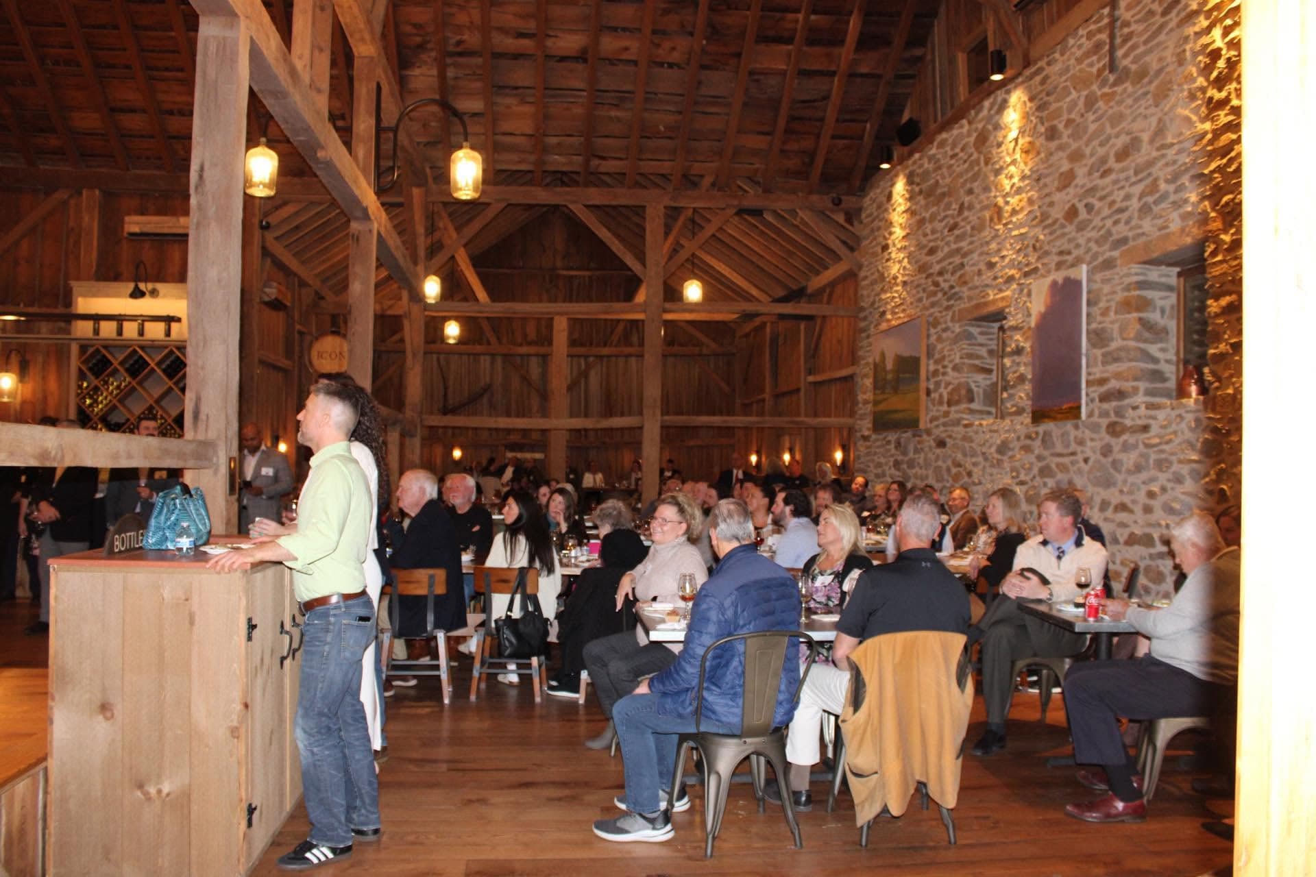 A full house at Boordy Vineyards — supporters at long tables under the barn’s lanterns and stone wall.