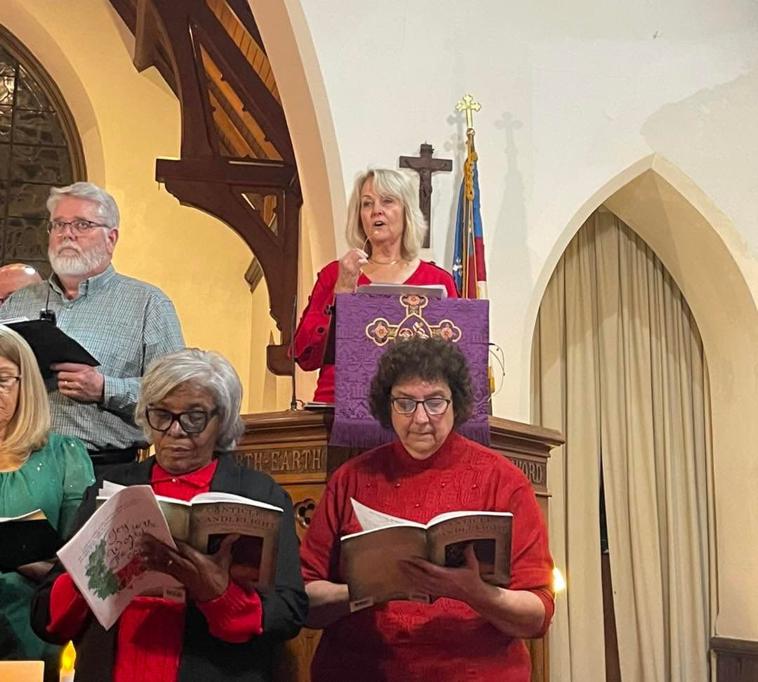 Kathy Szeliga speaking from the pulpit at her church, choir members singing in front.