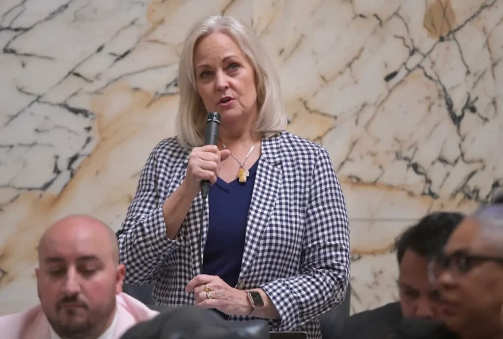 Kathy Szeliga speaking with a handheld microphone in the House chamber.